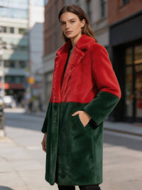 Side pose of a woman wearing a red and dark green bold statement colorblock faux fur coat with hand in pocket.