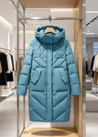 A light blue hooded puffer coat with a diamond quilted pattern hangs on a wooden hanger inside a modern retail display stand.