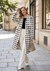Full-length street style shot of a woman walking in a monochrome houndstooth shawl-collar faux fur coat holding a beige handbag.