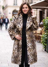 Three-quarter outdoor fashion look of a woman wearing an open-front leopard print faux fur coat with spread collar lapels.  