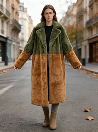 Model standing on a city street with arms slightly open wearing an olive green and rust colorblock faux fur long coat.