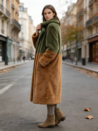  Side profile of a woman wearing an olive green and rust brown two-tone faux fur coat on a European street.

