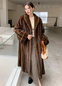 A slightly angled full-body shot of the woman posing in the brown faux fur coat, showcasing the drape of the garment and the wide shawl lapels.