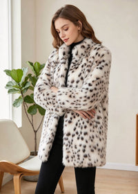 Three-quarter portrait of an elegant woman with crossed arms wearing a white and black snow leopard faux mink coat. 