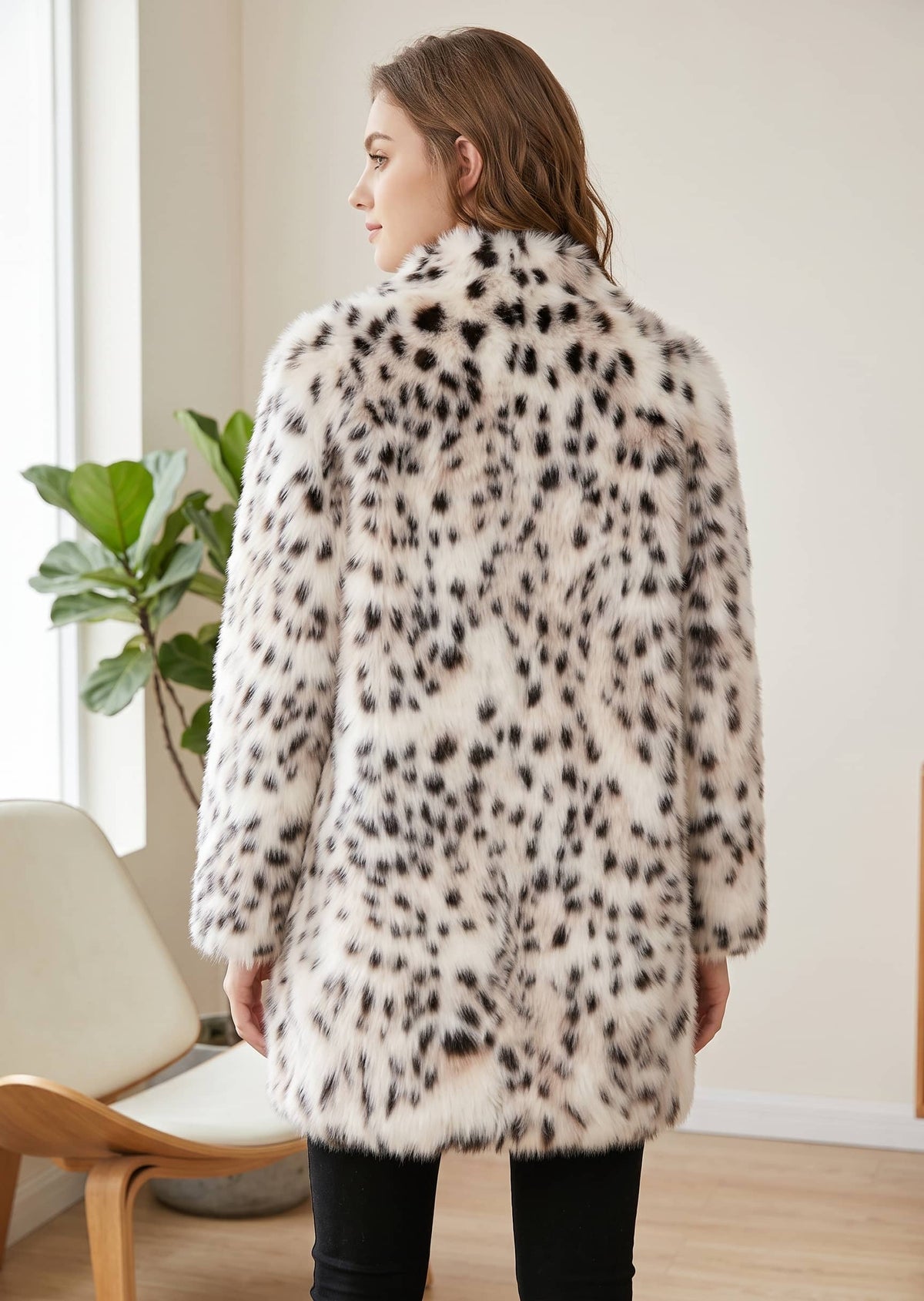 Back view showing the tailored mid-length cut, spotted pattern, and soft fur texture of the snow leopard faux mink coat. 