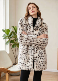 Front portrait of a woman with crossed arms highlighting the stand collar and spot pattern of the faux mink coat. 