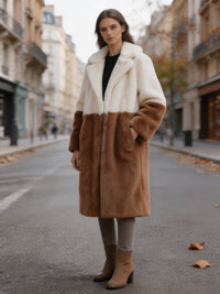 Model standing on a city street in an off-white and camel two-tone notch lapel faux fur long coat.