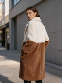 Back three-quarter view of a woman looking back in an off-white and camel colorblock faux fur coat.