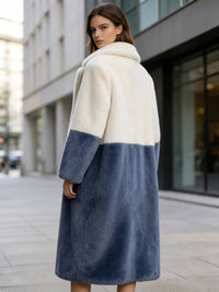 Back three-quarter view of a woman looking back in a cream white and slate blue color-block faux fur long winter coat.