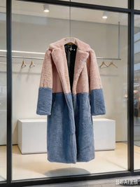 Dusty pink and slate blue color-block notch collar long faux fur winter coat hanging in a modern store display.