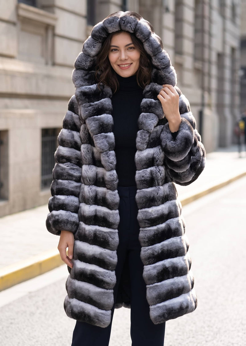 A woman wearing a long, plush hooded faux fur coat with horizontal gray and black stripes, standing on an outdoor city street.