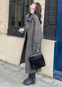 Side profile of a woman in a houndstooth coat looking upward while holding a small book and a black handbag.