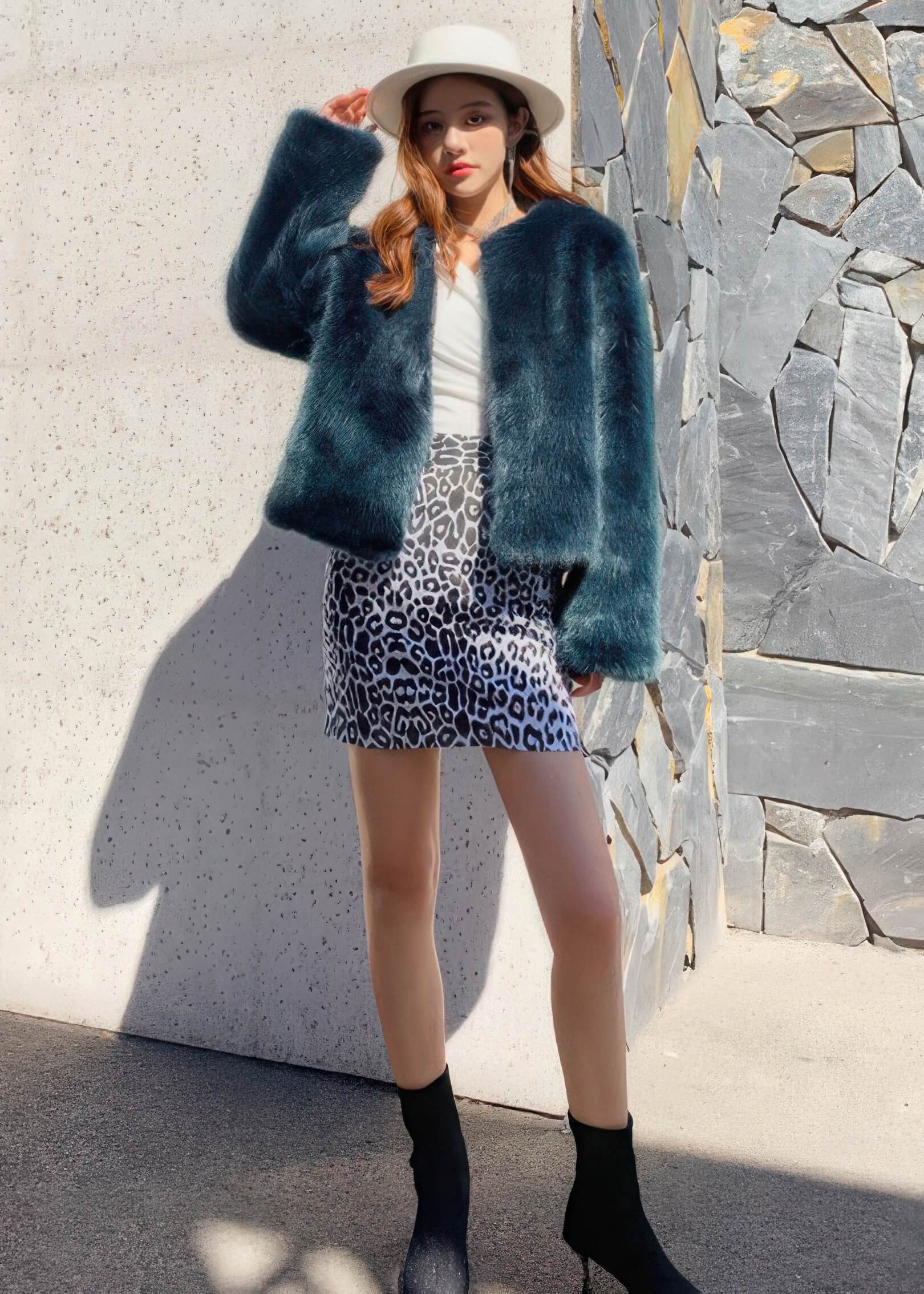 Street style fashion featuring a teal green fluffy faux fur jacket, white hat, and animal print mini skirt.