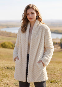 Medium shot of woman modeling winter white chevron shawl collar faux fur jacket