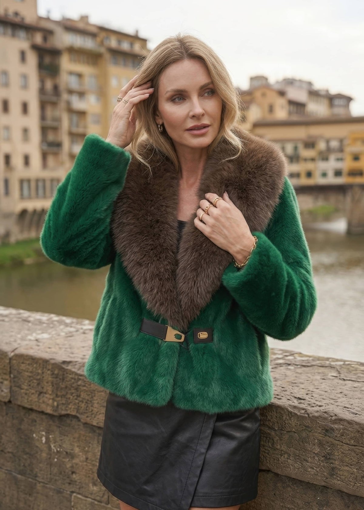Woman wearing emerald green faux fur jacket with dark brown contrast collar and waist buckle