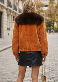 Back view of woman wearing orange faux fur jacket with dark brown contrast fur collar
