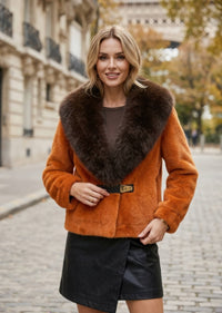 Front view of woman in orange faux fur jacket with dark brown contrast fur lapel and gold buckle detail