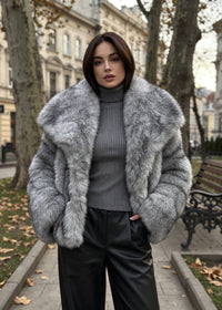 Close-up portrait of a woman showcasing the plush texture and wide spread collar of a gray winter faux fur jacket