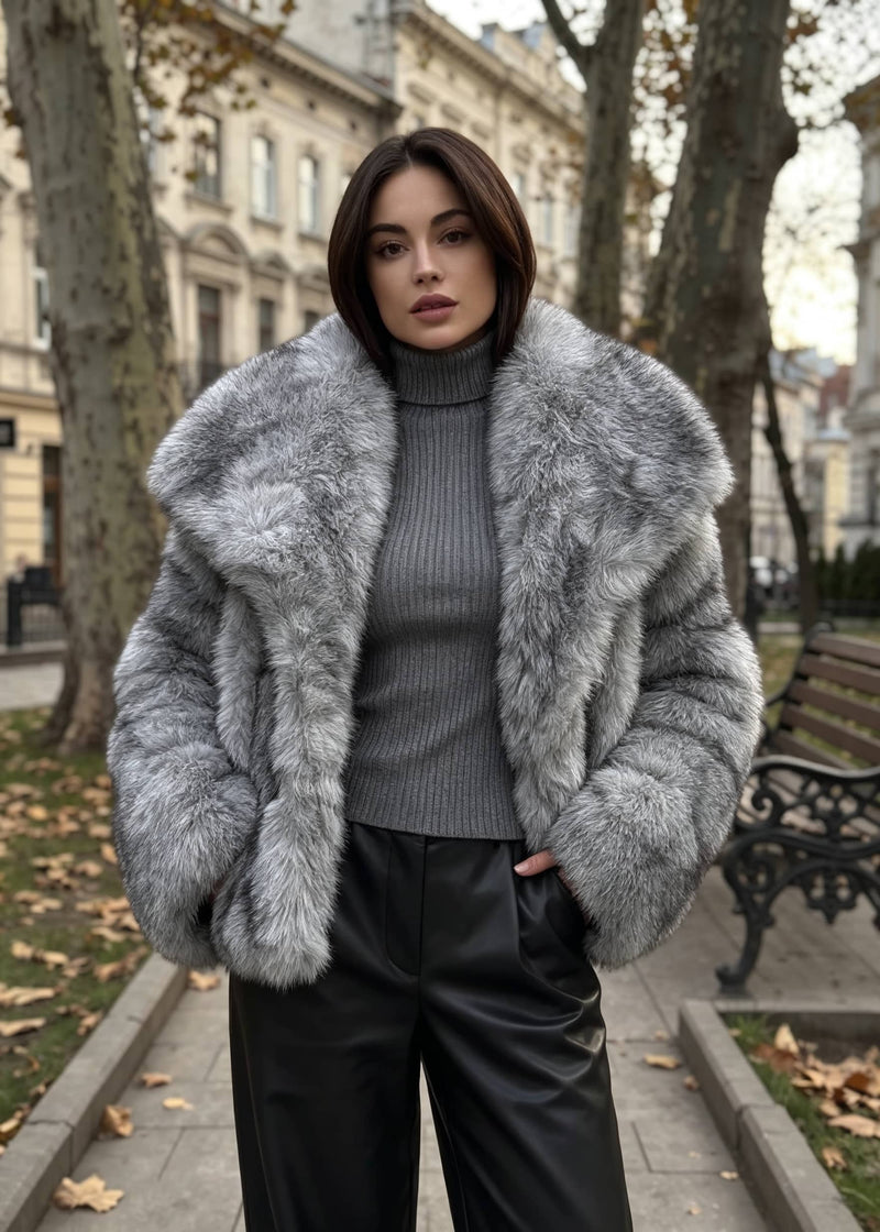 Close-up portrait of a woman showcasing the plush texture and wide spread collar of a gray winter faux fur jacket