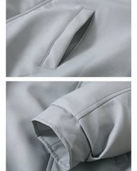 Close-up detail of side pocket stitching and smooth cuff on grey faux leather jacket.
