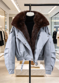 Light blue faux leather jacket with plush dark brown faux fur collar and adjustable waist belt on display hanger.
