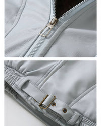 Close-up details of front zipper closure and adjustable brass buckle belt on light blue faux leather jacket.