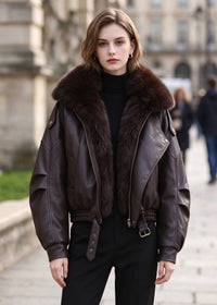 Model wearing dark brown faux leather motorcycle jacket with dark brown faux fur collar standing outdoors