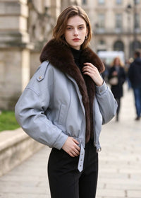 Three-quarter side angle of model wearing light blue faux leather jacket with faux fur trim collar.