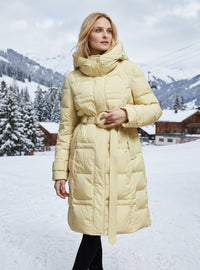 Elegant light yellow women's down puffer coat with belted ring buckle and deep side pockets styled for cold winter weather.