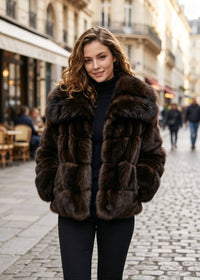 Full front-facing street view of a woman walking in an open espresso brown dramatic oversized collar faux fur cropped coat