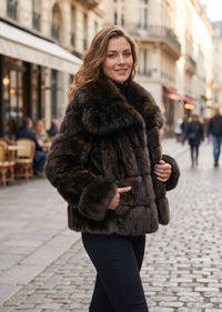 Three-quarter street portrait of a woman styling an open espresso brown tiered panel faux fur jacket with wide folded lapels