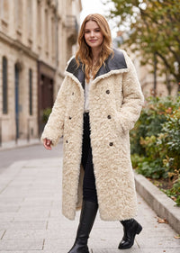 Reversible styling showing the coat worn with the cream faux shearling fleece exterior and leather turn-down collar.