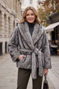 Woman carrying a handbag while wearing a dark heather gray faux fur wrap coat with a belted waist