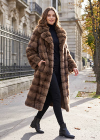 Studio retail hanger display of a women's luxury brown tiered wing collar faux fur long coat on a rack