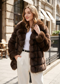 Fashion street style shot of a woman with hand in pocket wearing an open front sable brown tiered wing-collar faux fur jacket