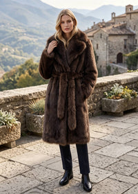 Three-quarter portrait of a model wearing a belted deep brown faux fur coat with oversized lapels.