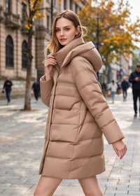 Dynamic three-quarter walking view of model wearing a warm camel brown down puffer coat showing hooded collar and textured bodice.