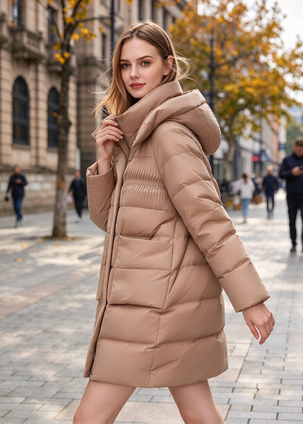 Dynamic three-quarter walking view of model wearing a warm camel brown down puffer coat showing hooded collar and textured bodice.