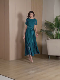 Video showcasing the movement and shimmer of the Elegant Green Floral Jacquard Maxi Dress as a model walks and poses.