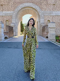 Elegant Vivian Seven leopard print maxi dress, ideal for parties and events. Features V-neckline, long sleeves, and flowy chiffon skirt. Cinch the waist with the included black statement belt with gold double-ring hardware for a sophisticated silhouette. Pairs perfectly with heels for a boho-chic look.
